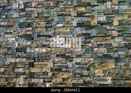 Decorative wall made of processed stones. Different types of decorative stone Stock Photo
