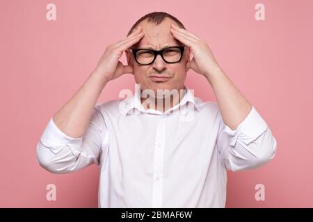 Stressed young man in eyeglasses regretting about something, looking at camera. Stock Photo