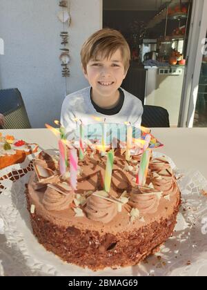 birthday boy with birthday cake and burning candles for his 10th birtday, Germany Stock Photo