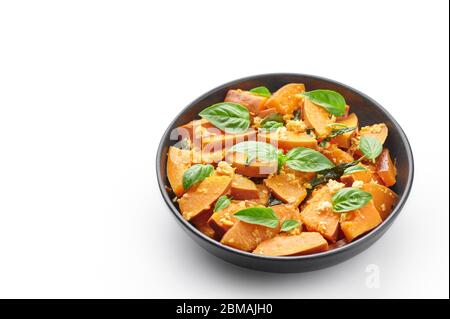 Pad Faktong or Thai Stir-fried Pumpkin in black bowl isolated on white background. Pad Phuk Tong is thailand cuisine dish with sliced Kabocha Squash, Stock Photo