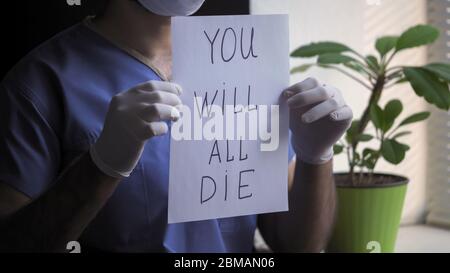 Male Doctor Shows Bad Prediction about death Holding Paper Blank with an inscription that everyone will die. Unfavorable prognosis of the disease Stock Photo