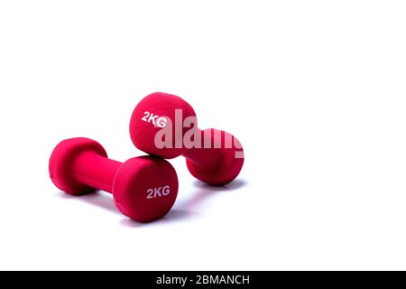 Set of red dumbbells isolated on white background. A pair of red neoprene dumbbells. Home gym equipment for exercise at home. Weight training Stock Photo