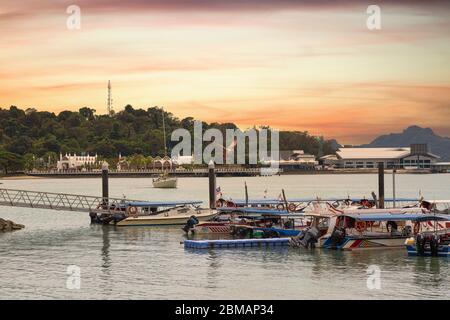 Kuah Langkawi Malaysia - 12 Nov 2017. Fishing boats in Kuah Bay, sculptured eagle can be seen in background. Stock Photo