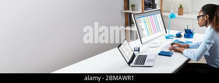 Black Person Working With Spreadsheet Data On Computer Screen Stock Photo