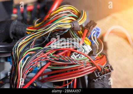 A bunch of multi-colored electrical wires - blue, green, red and yellow, interconnected in the nodes of the car when the network is repaired by an eng Stock Photo