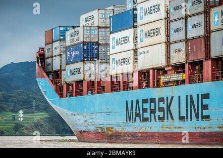 Maersk container ship coming up on turn on stormy day in Panama Canal. Stock Photo