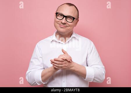 Smiling mature man in glasses and white shirt standing looking at camera Stock Photo