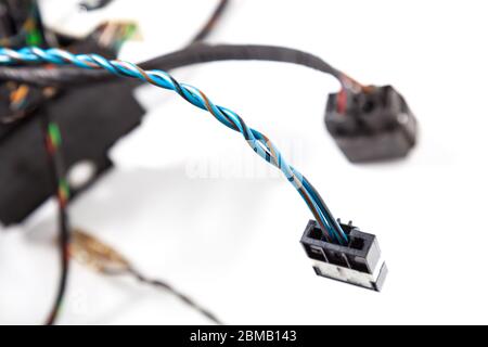 Two twisted blue electrical wires with a black connector closeup on a white background and other cables. Installation and connection of Internet daily Stock Photo
