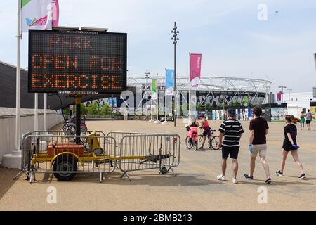 London, UK. 8th May, 2020. UK Weather: People exercising in the Queen Elizabeth Olympic Park. Information board reminds people about the coronavirus lockdown rules. Credit: Marcin Rogozinski/Alamy Live News Stock Photo