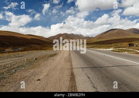 asphalt road M41, Bishkek Osh highway in Suusamyr valley of Kyrgyzstan. Stock Photo