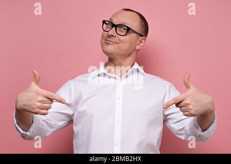 Man smiling and pointing at himself with index fingers being self confident. Stock Photo