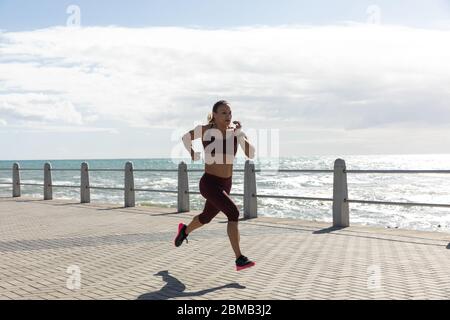 Sporty Caucasian woman training on seaside Stock Photo