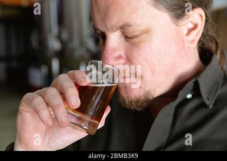 Caucasian man tasting beer in a brewery Stock Photo