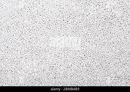 Background of gray color with a pattern of oval and round parts of polystyrene similar to sea pebbles pressed and used to trim or protect fragile part Stock Photo