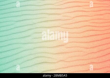 Sand stripes made by water waves texture background. Toned to torquoise blue-red gradient. Summer vacation, holiday at sea concept. Stock Photo