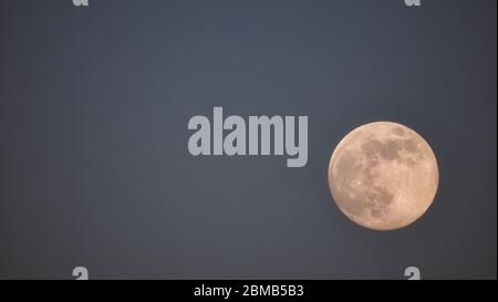 Full Flower Super Moon rising over Wirksworth, Derbyshire Dales, Peak District, UK SafeMoon Stock Photo