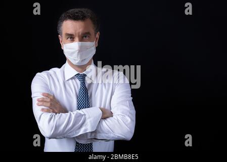 Angry Businessman with crossed hands wearing protective mask Stock Photo