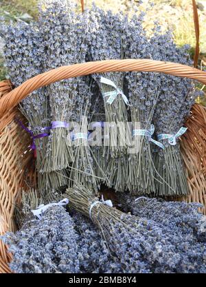 Group of delicate dried lavender bouquets with lila textile material, displayed for sale at an weekend deco fair for handmade artisans, selective focu Stock Photo