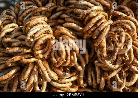 German pretzels stack one over each other, group of thin dry pretzels on rope on display on a table at a food market festival, traditional food Stock Photo