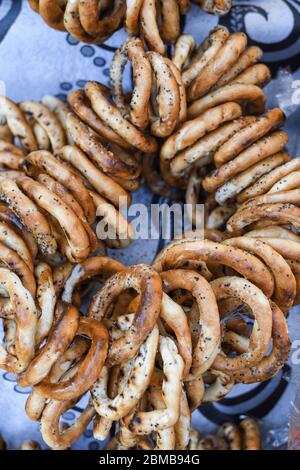 German pretzels stack one over each other, group of thin dry pretzels on rope on display on a table at a food market festival, traditional food Stock Photo