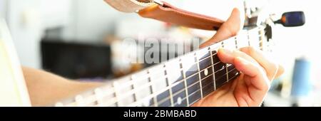 Man plays guitar, male hand holds neck guitar Stock Photo