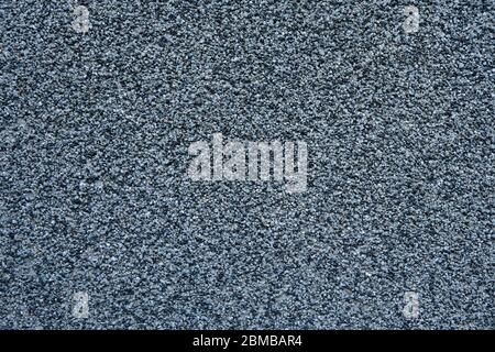 Wall made of small black and grey stones backgrounds. Gravel on cement. Concrete mix texture wall. Stock Photo