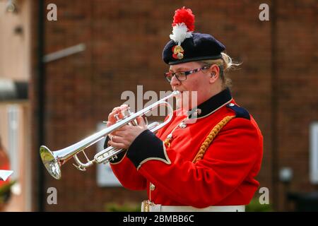 Dudley, UK. 8th May, 2020. Trumpeter Sam Chater, 35, of the band of the Royal Regiment of Fusiliers, Warwickshire, plays the Last Post outside her home in Dudley, West Midlands, UK. Credit: Peter Lopeman/Alamy Live News Stock Photo