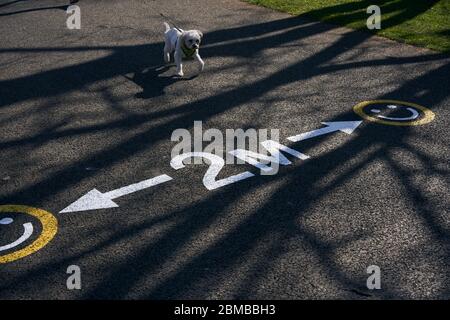 A social distancing sign painted on the pavement in a Dublin park during the Coronavirus pandemic, Ireland. Stock Photo