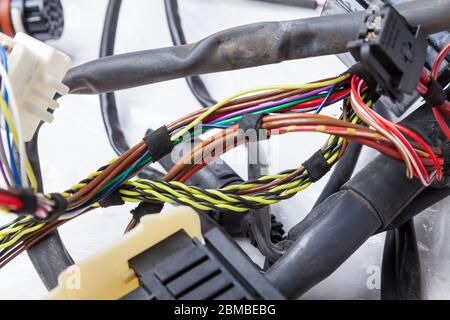 A coil of multi-colored electrical wires and pretangled yellow and black, connected at the nodes of the car during network repair by an engineer or me Stock Photo