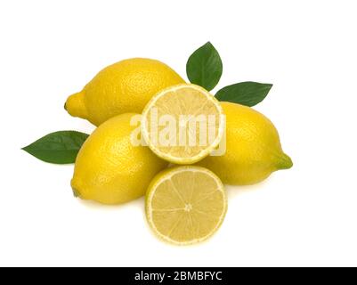 Three whole yellow lemons and two halfs with green leaves isolated on white background Stock Photo