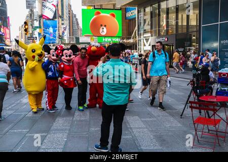 Tourists taking photos with costumed characters in Times Square, New York City Stock Photo