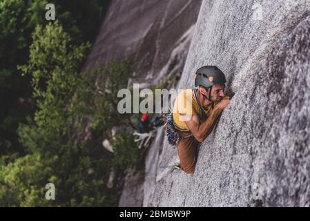 man trad rock climbing lead on granite wide crack Squamish Canada Stock Photo