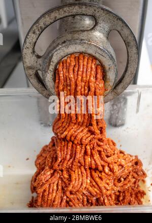 Frontal view of meat coming out of the grinder at a butcher shop Stock Photo