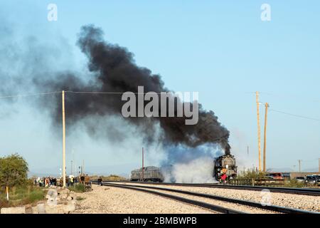 Steam engine throwing up black smoke as it starts to move on tracks Stock Photo