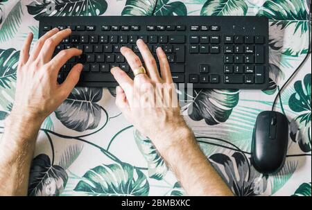 male hands typing on computer keyboard, top view Stock Photo