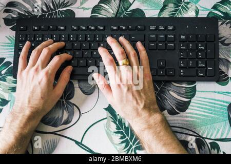 male hands typing on computer keyboard, top view Stock Photo