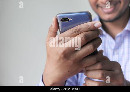 Close up of a happy young man using mobile smart phone Stock Photo