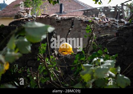 Yellow helmet on the wall in a construction site Stock Photo