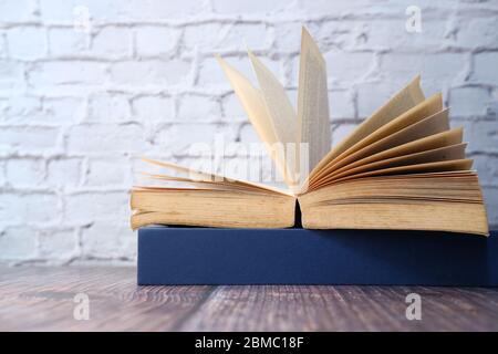 open book on table against a wall. Stock Photo