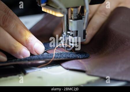 Man sewing a leather on shoe sewing machine for making shoe Stock Photo