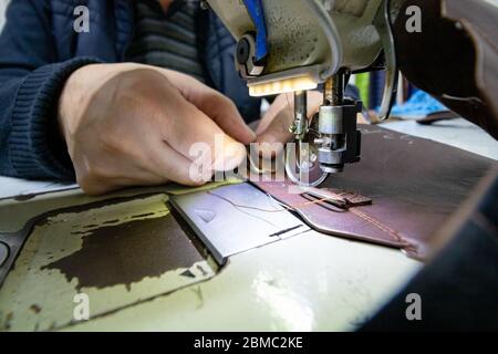 Man sewing a leather on shoe sewing machine for making shoe Stock Photo