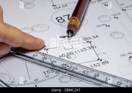Men holding a pen for pointing the architectural plan Stock Photo
