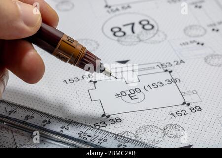 Men holding a pen for pointing the architectural plan Stock Photo