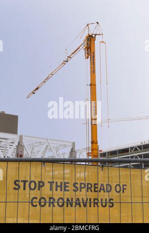 Veldhoven, The Netherlands, May 8th 2020. Stop the spread of the Corona virus, a text on a yellow texile information sign at a construction site with Stock Photo