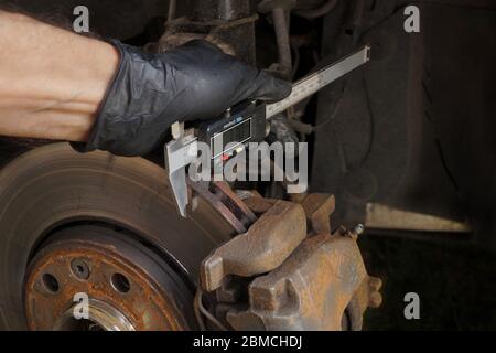 Assessment of technical condition, thickness measurement with digital calipers. Brake discs. Stock Photo