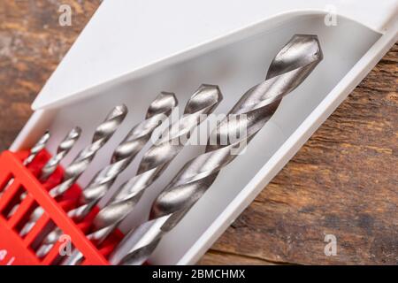 Metal drill bits in the container. DIY accessories in a workshop. Dark background. Stock Photo