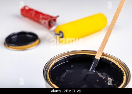 Black paint can and paint roller. Paint application accessories. Light background. Stock Photo