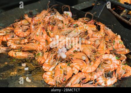 Fresh shrimps seafood mix cooking steaming in large wok pan during hotel brunch buffet outside outdoor in the garden by the pool. Fresh Food Buffet Br Stock Photo