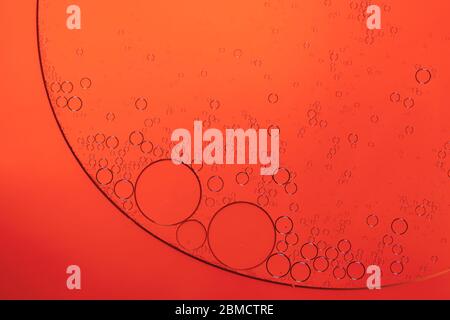 Circular shapes of seprerated oil on the surface of water - creative macro background Stock Photo