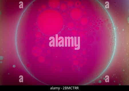 Circular shapes of seprerated oil bubbles on the surface of water - creative macro background Stock Photo